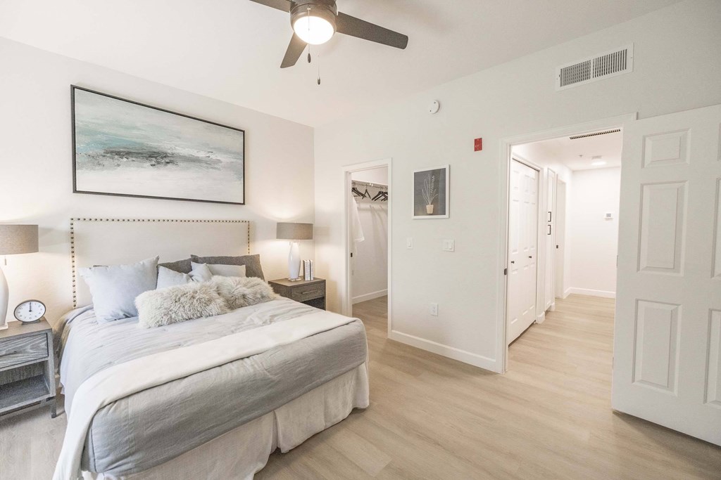 A bedroom with a large bed and a ceiling fan.