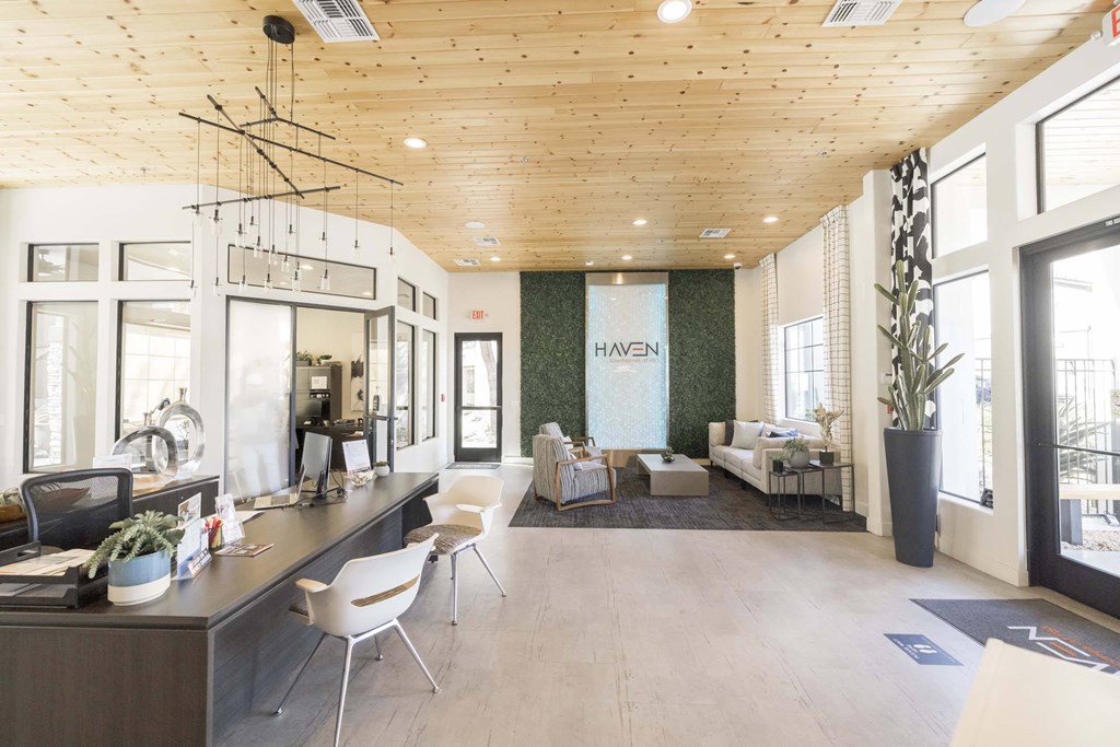 A modern office space with a reception desk and seating area.