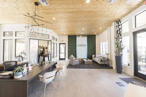 A modern clubhouse with a reception desk and seating area.