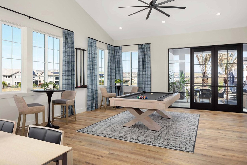 A room with a pool table and a ceiling fan.