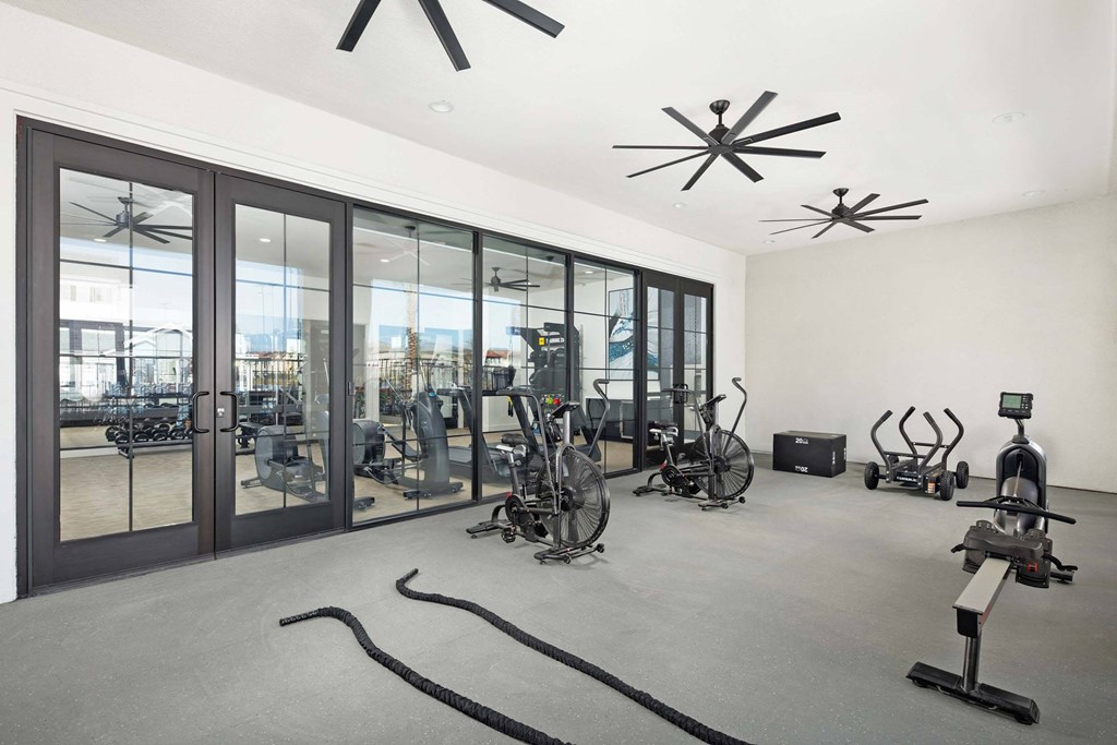 A gym with exercise equipment and a large window.