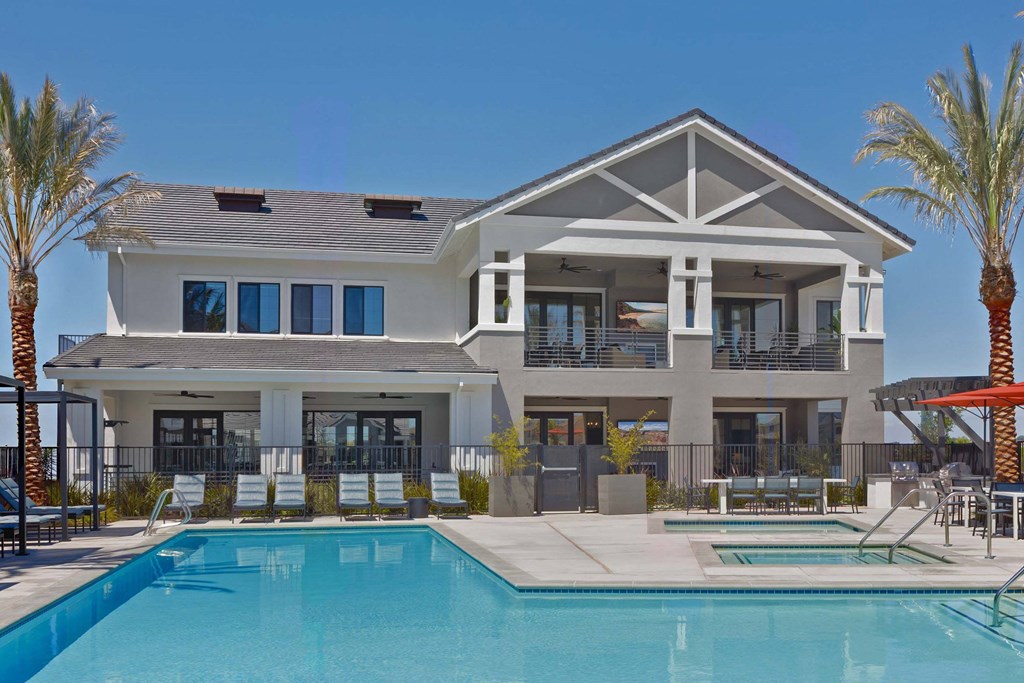 A large house with a pool in front.