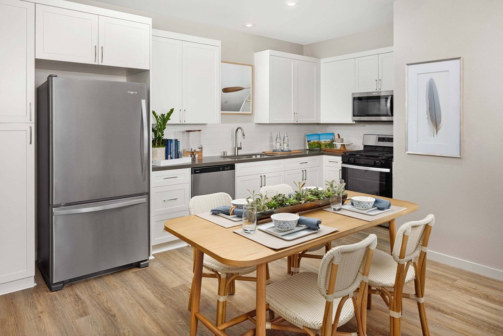A modern kitchen with a dining table and chairs.