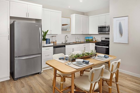 A modern kitchen with a dining table and chairs.