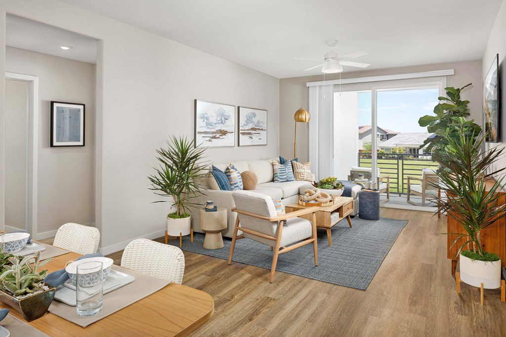 A living room with a couch, chairs, and a dining table.