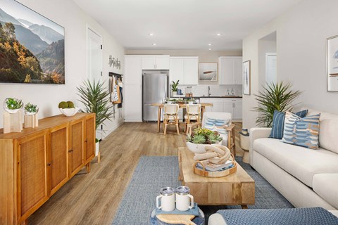 A living room with a wooden floor and a large painting on the wall.