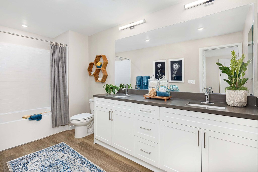 A bathroom with a white tub, toilet, and sink.