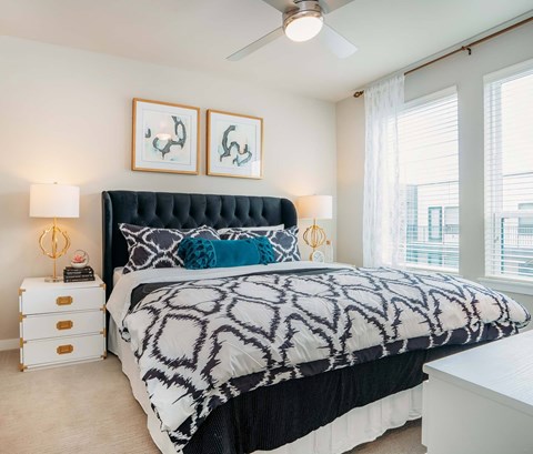 A bedroom with a large bed and two framed pictures on the wall.