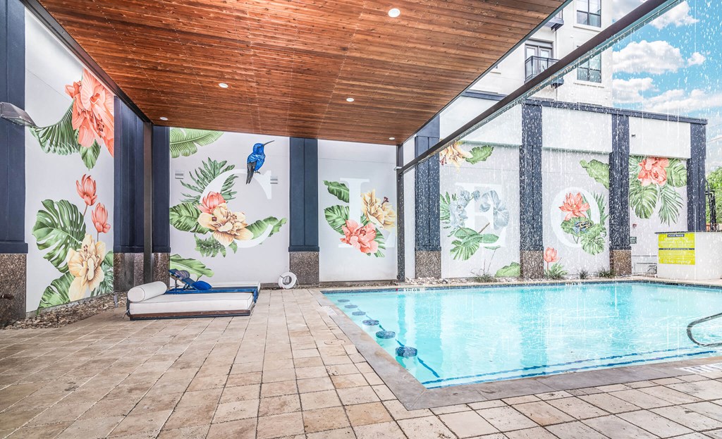 A pool inside a room with a wooden ceiling.