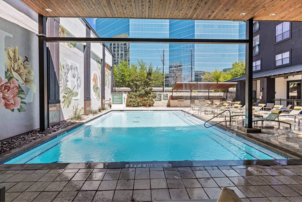 A pool with a wooden ceiling and tiled floor.