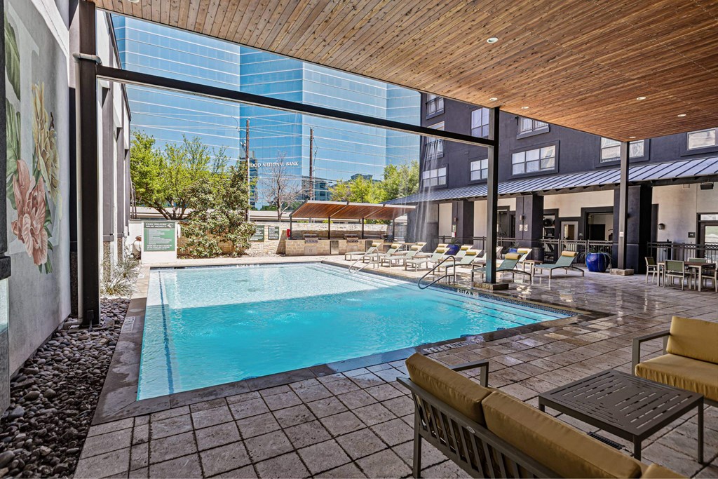 A pool area with a bench and a table.