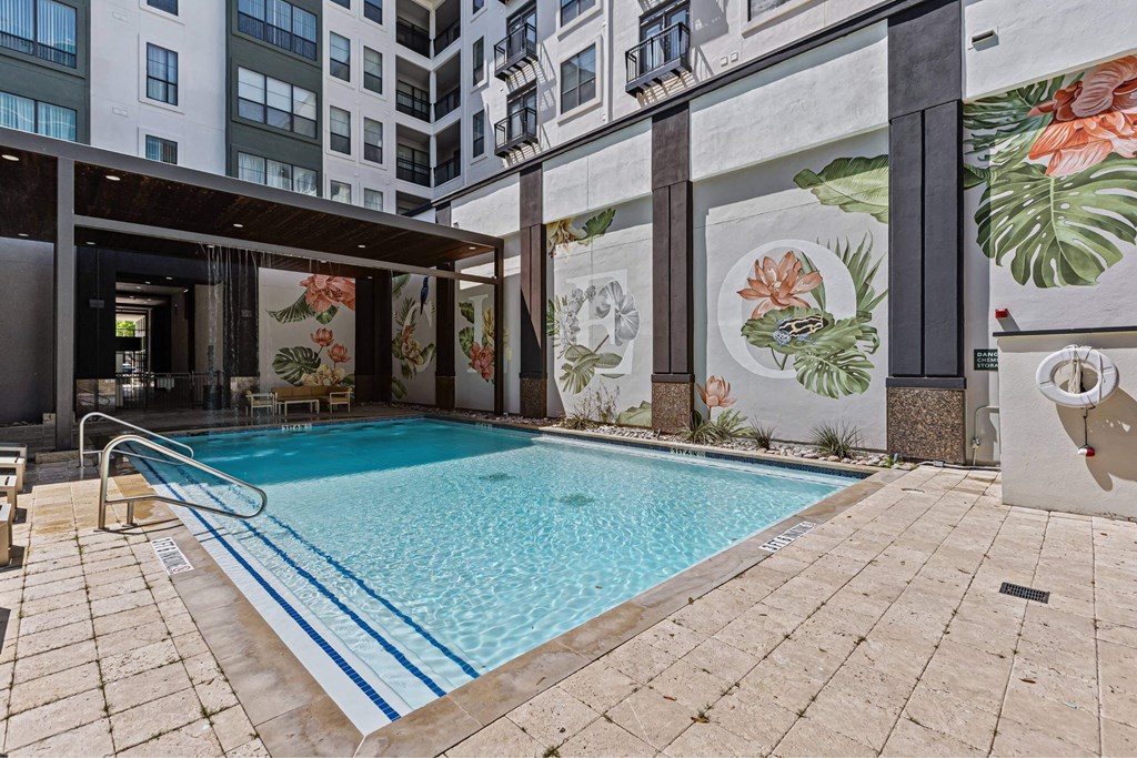 A pool surrounded by a mural of flowers.