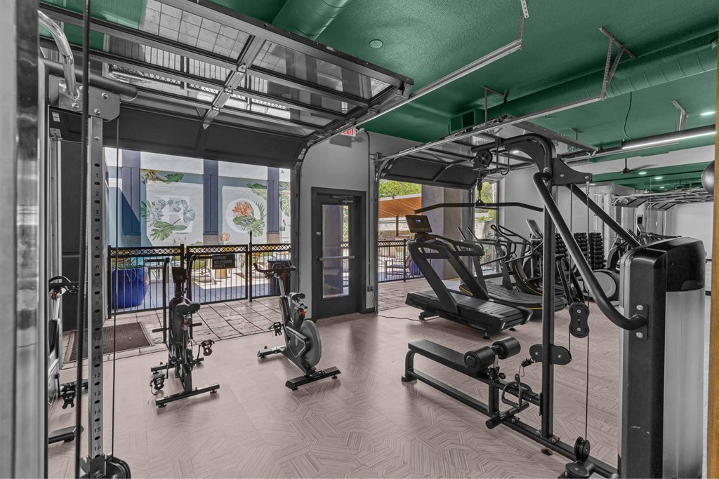 A gym with a variety of equipment including treadmills, weights, and exercise machines.