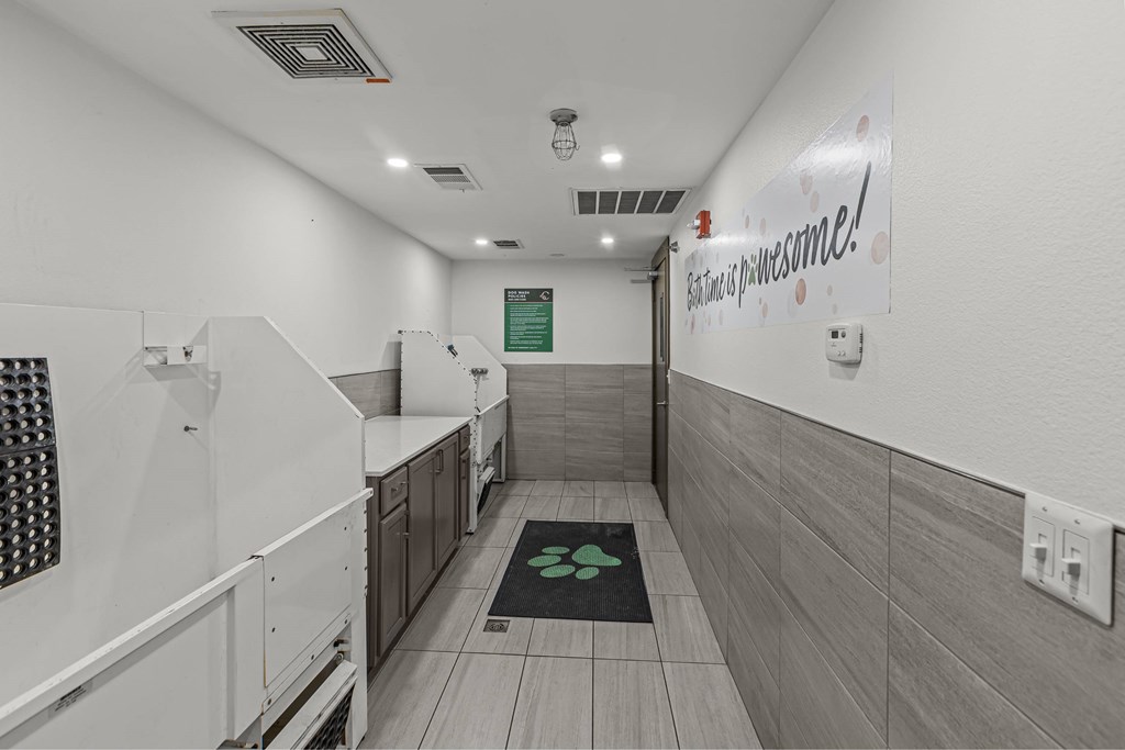 A hallway with a green mat on the floor and a sign on the wall that says "Welcome!".