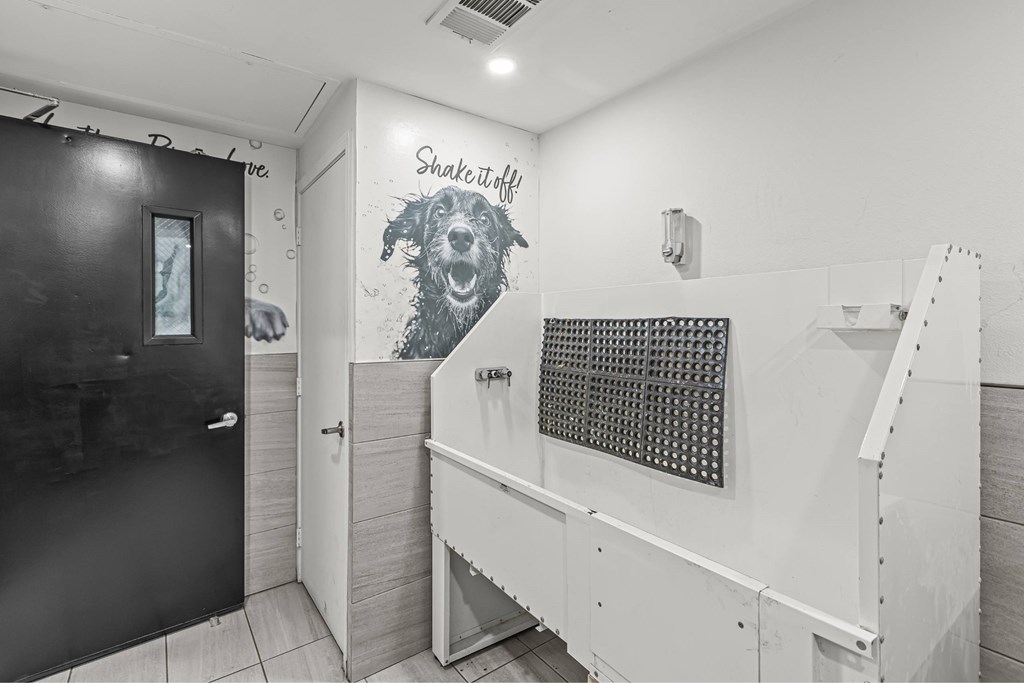 A bathroom with a Shake Shack dog mural on the wall.