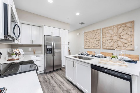 A modern kitchen with white cabinets and stainless steel appliances.
