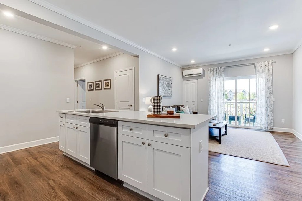 A kitchen with white cabinets and a black dishwasher.