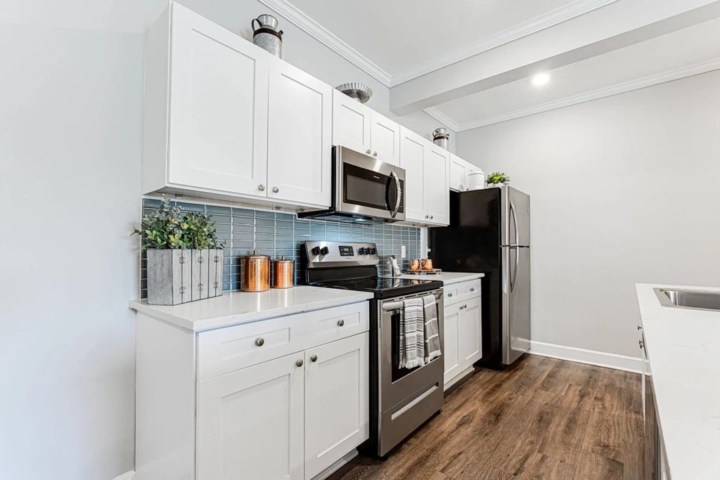 A kitchen with white cabinets and a black stove top oven.