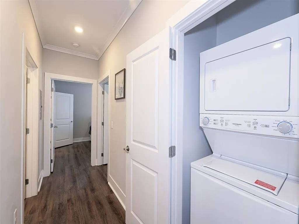 A white dryer is sitting in a laundry room with a washer and a small closet.