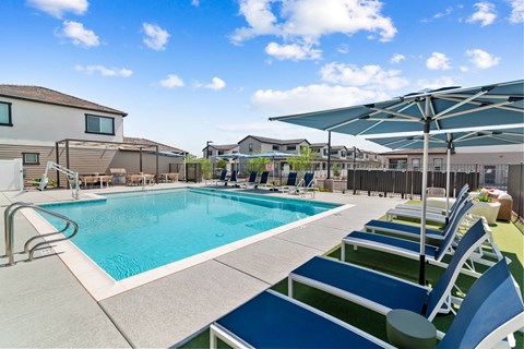 A swimming pool with blue water and a white fence around it.