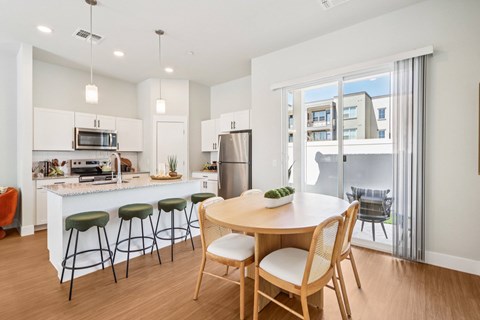 A modern kitchen with a dining table and chairs.