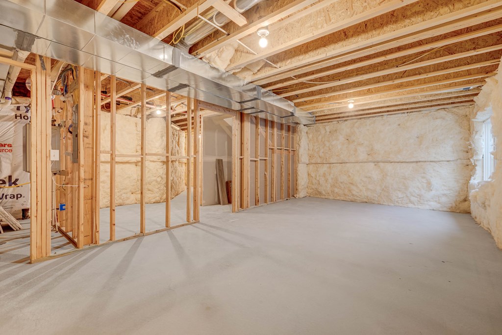 A room under construction with wooden framing and insulation on the walls.