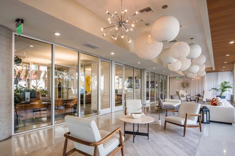 A modern living room with white furniture and a chandelier.
