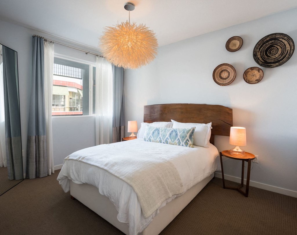 A bedroom with a large bed and a wooden headboard.