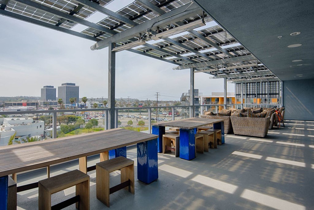 A rooftop patio with a table and chairs.