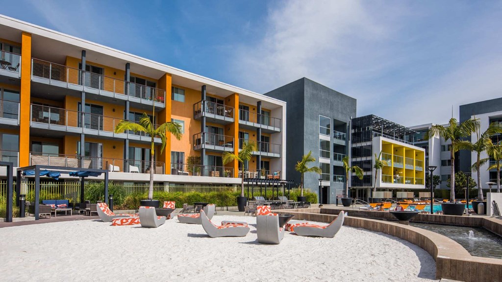 A modern building with a sandy area in front.