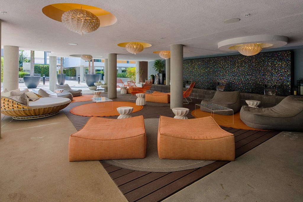 A modern living room with orange furniture and a mosaic wall.