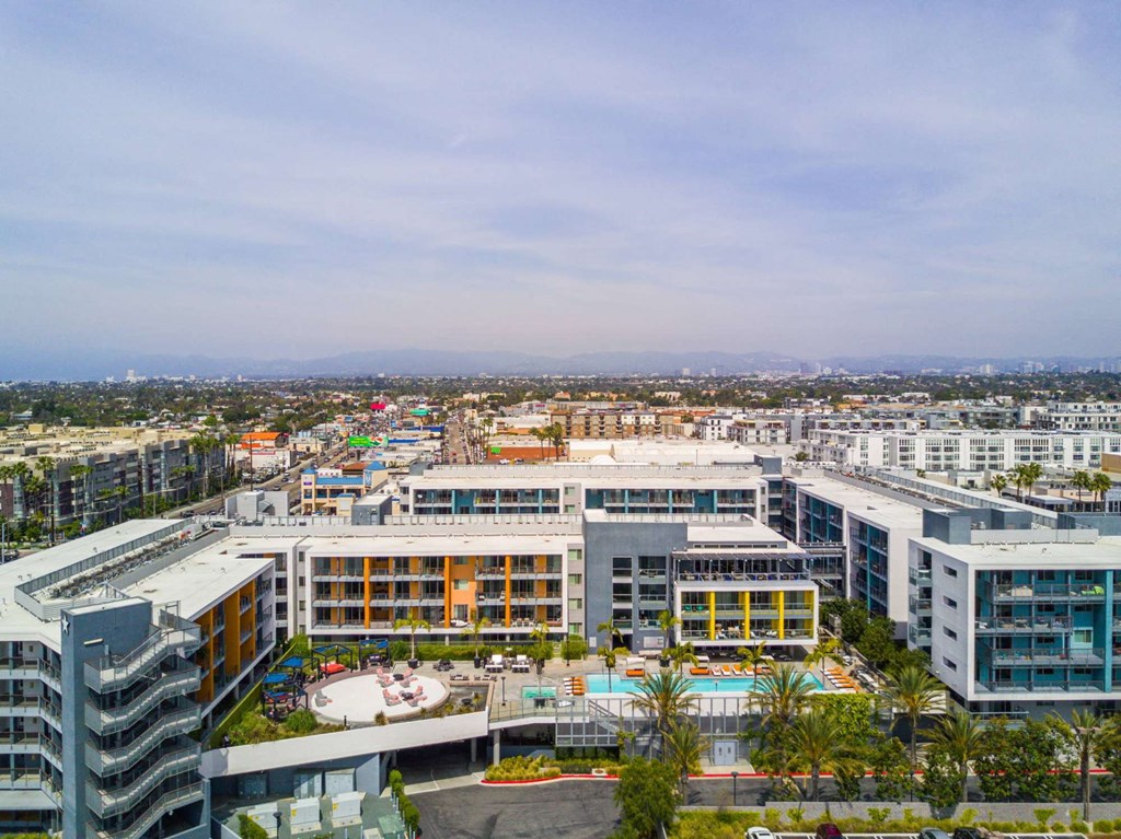 A view of a cityscape with buildings and a pool in the foreground.