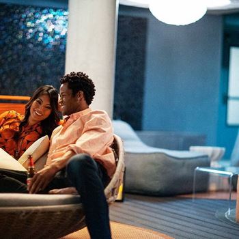 A man and woman are sitting closely together on a couch.