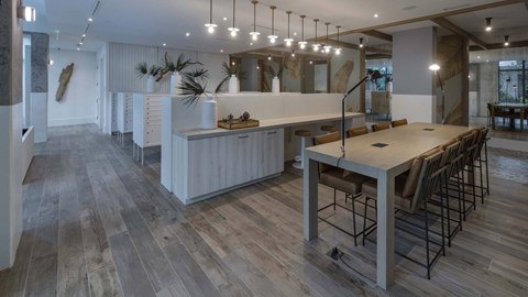 A modern kitchen with a long table and chairs.