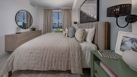 A bedroom with a large bed and a green dresser.