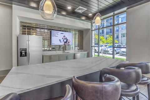 A modern dining area with a long table and leather chairs.