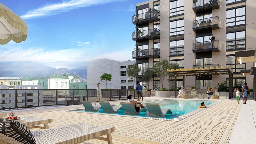 A large outdoor pool area with people enjoying the sun and water.