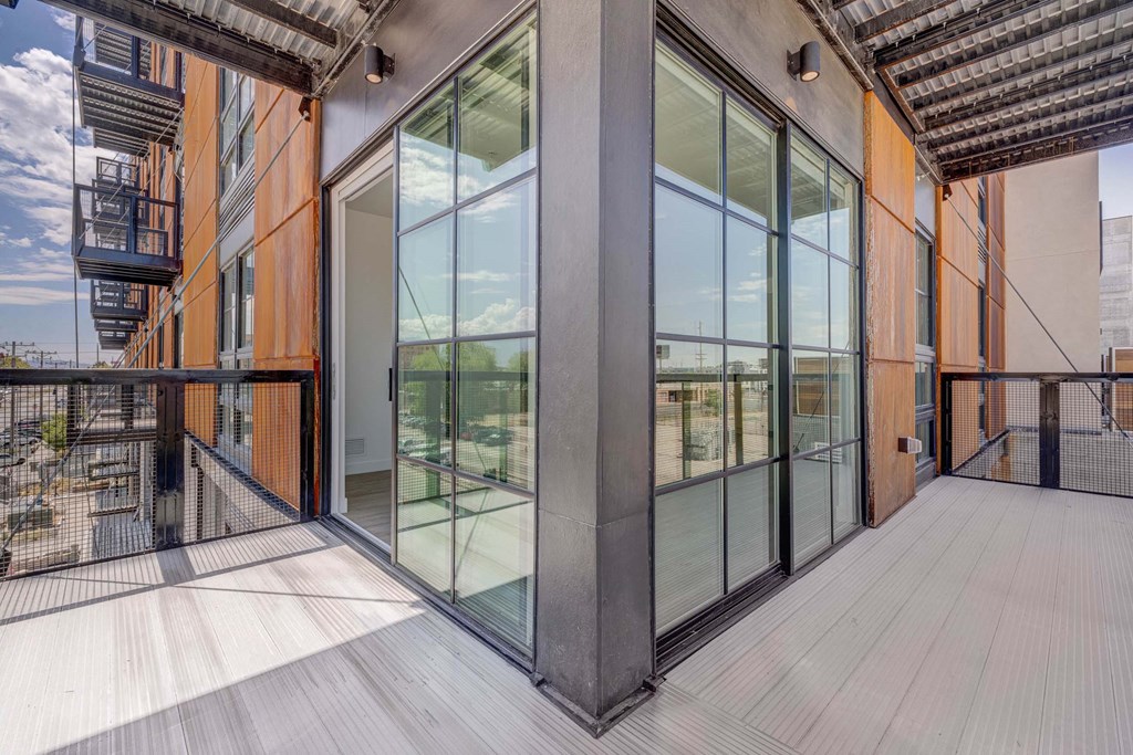 A balcony with glass doors and a wooden floor.