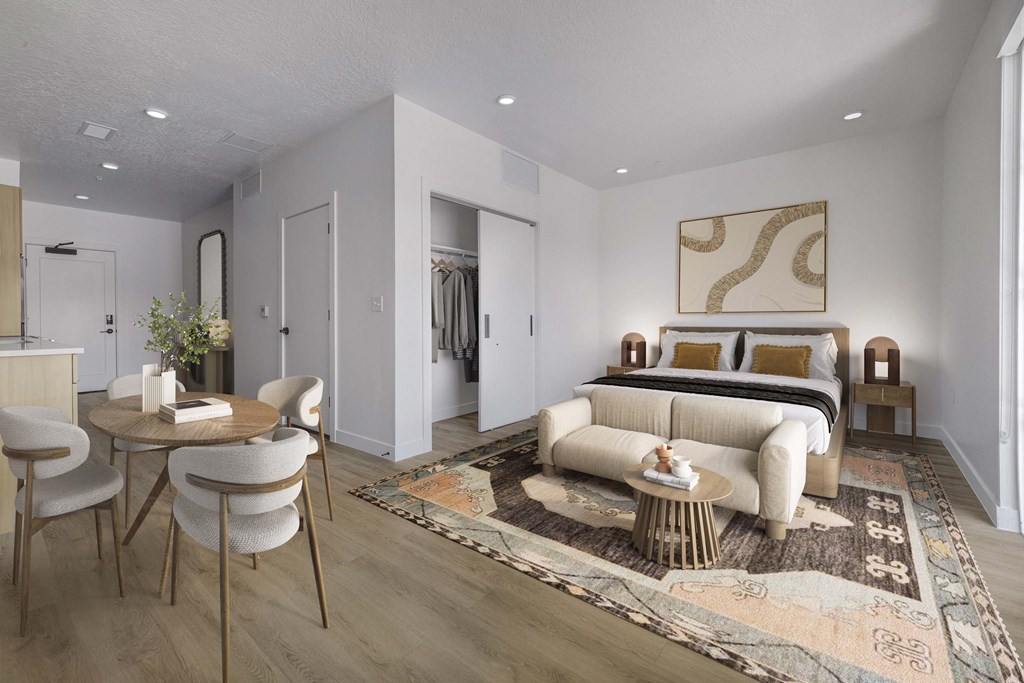 A modern living room with a sofa, chairs, and a rug.