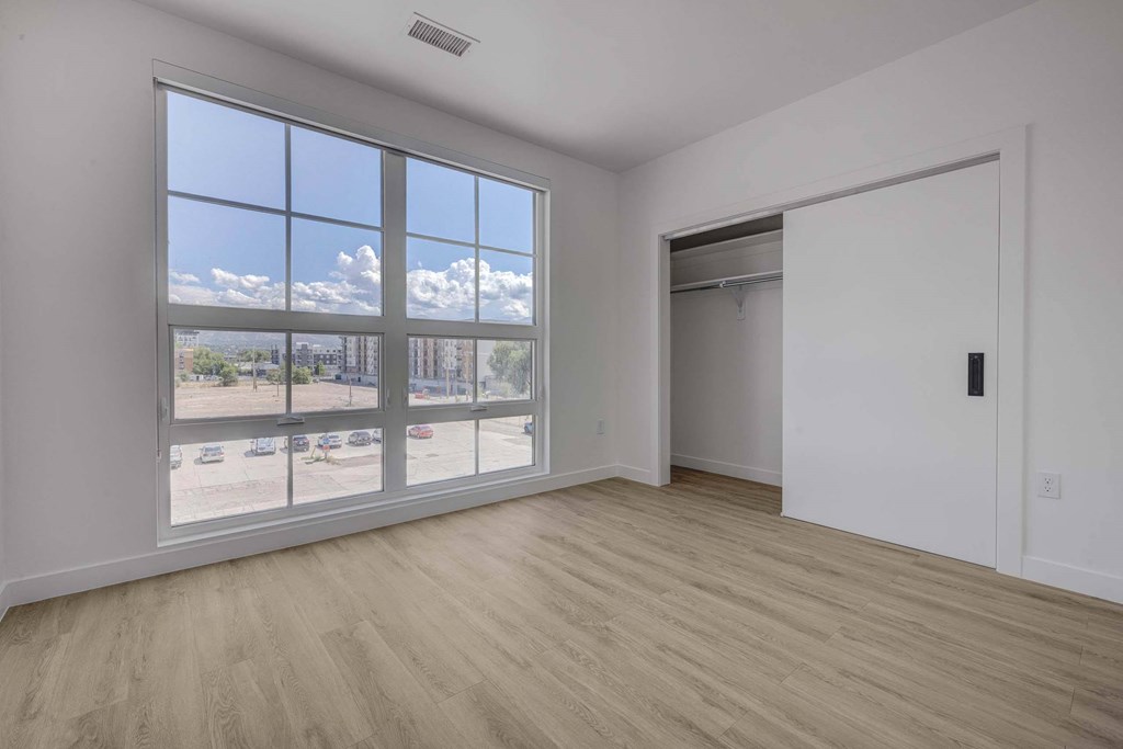 A room with a large window overlooking a parking lot.