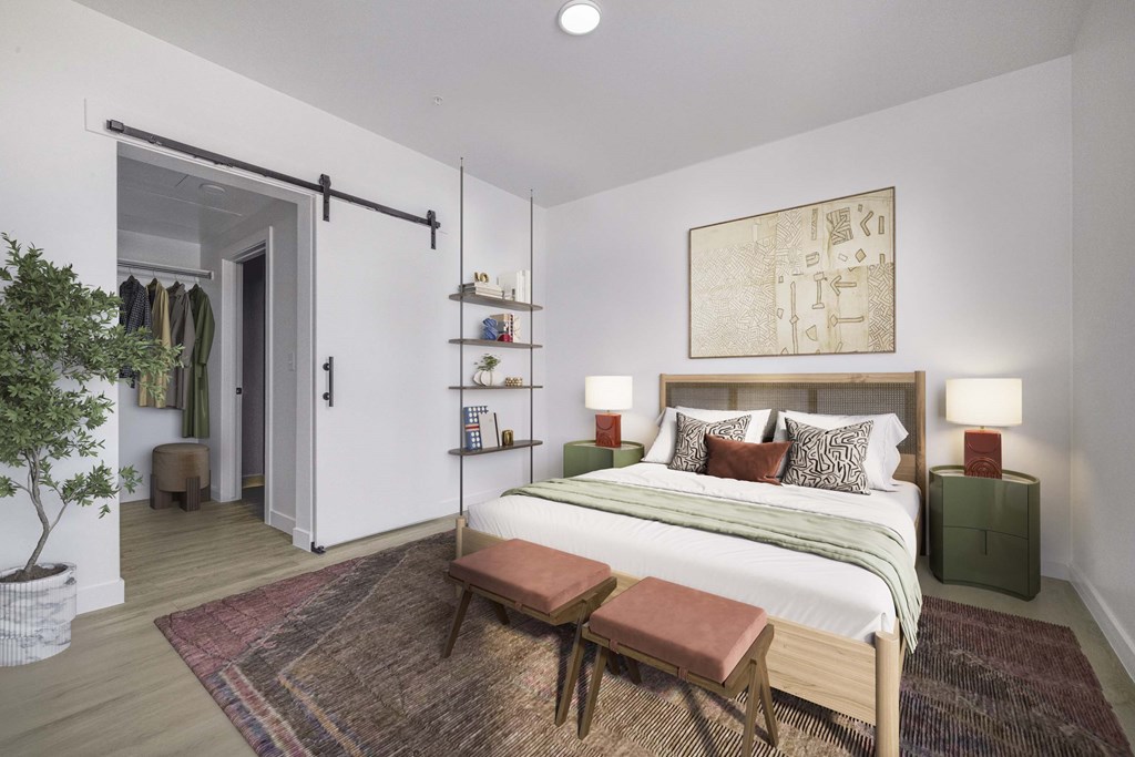 A bedroom with a bed, a bench, and a painting on the wall.