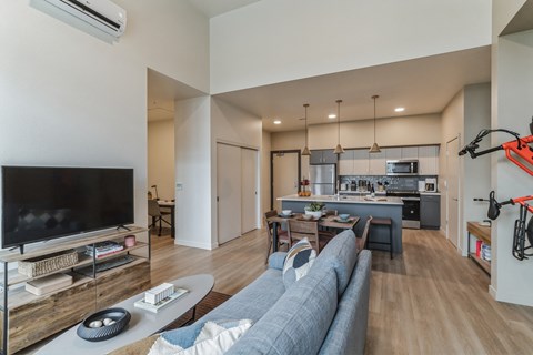 A modern living room with a grey sofa and a television.