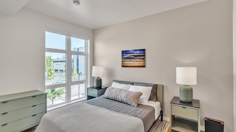 A bedroom with a large bed and a painting on the wall.