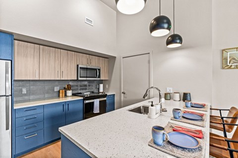 A kitchen with a blue cabinet and a white counter.