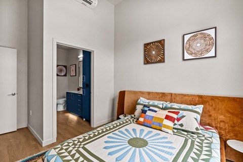 A bedroom with a bed and two pictures on the wall.