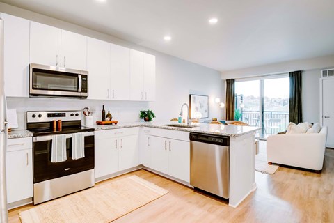 A modern kitchen with white cabinets and stainless steel appliances.