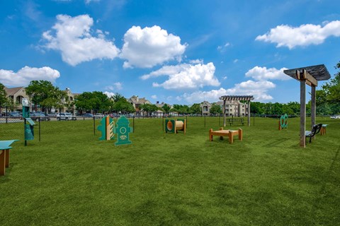 A park with a green lawn and a blue sky.