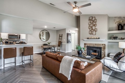 A living room with a brown couch and a fireplace.