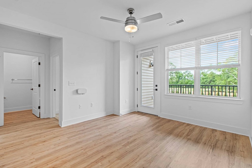 A room with a ceiling fan and wooden flooring.