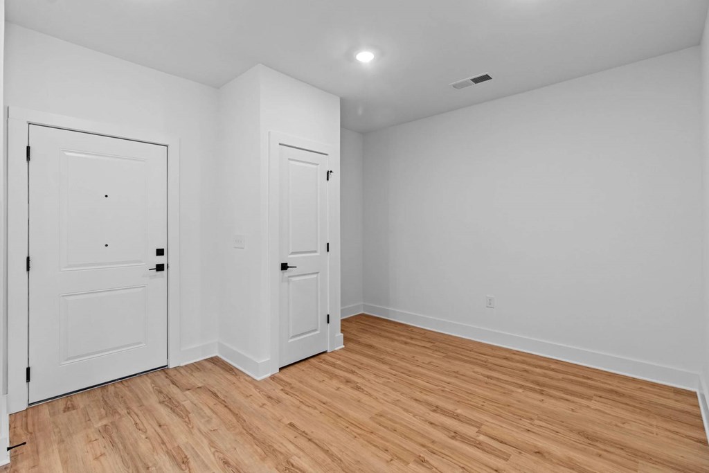 A room with two doors and a wooden floor.